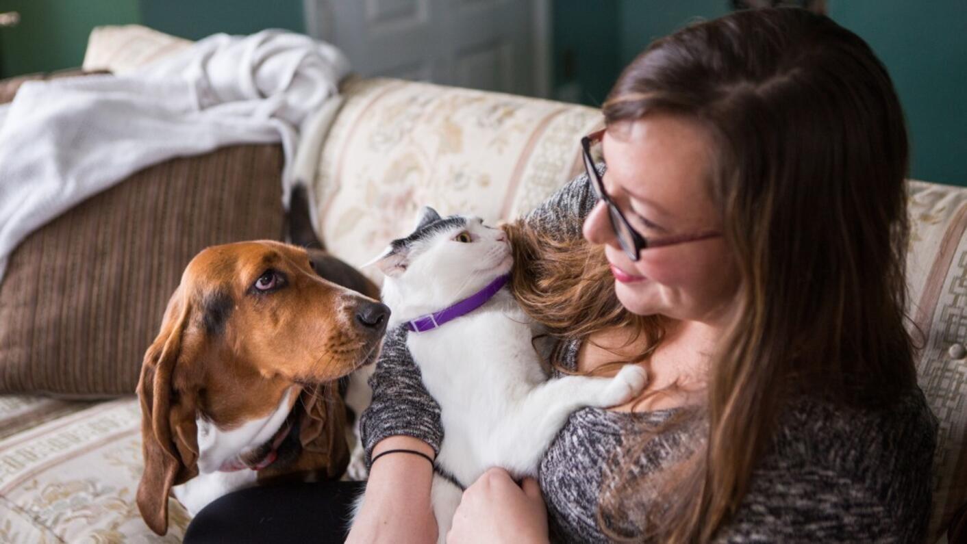 Жінка з котом та собакою на дивані